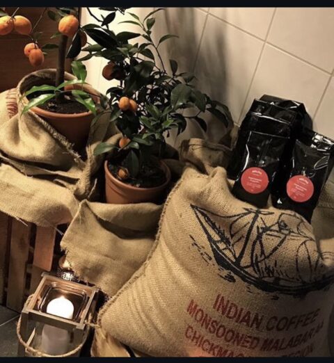 Kaffesäckar med gröna bönor och påsar med Melins egenrostade kaffe